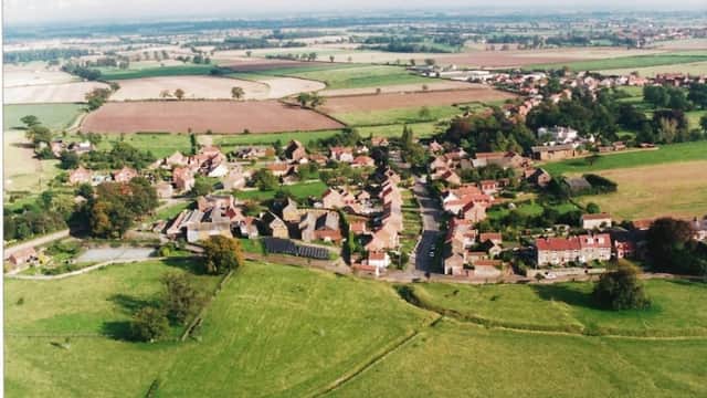 Aerial view of Whixley Village Hall surrounded by greenery, fields, and residential homes in Yorkshire.