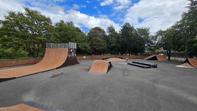 Skatepark featuring a vert ramp, various ramps, and rails surrounded by trees and cloudy sky in Norton, Yorkshire.