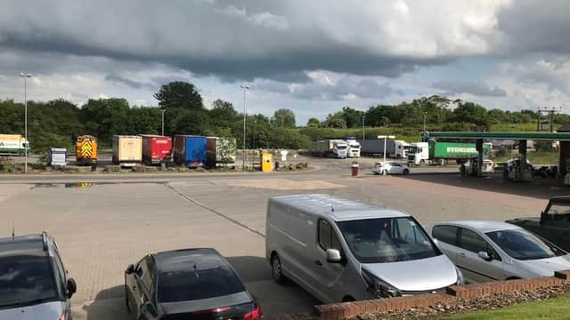 Trucks and vehicles parked at a service station in Barton, Yorkshire, under a cloudy sky.