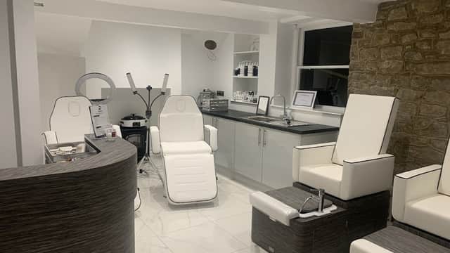 Modern beauty salon interior with sleek white chairs, a reception desk, and stylish decor in a serene setting.