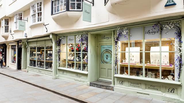 Quaint jewellers' shopfront with large windows displaying fine jewellery and floral decorations in Leeds, Yorkshire.