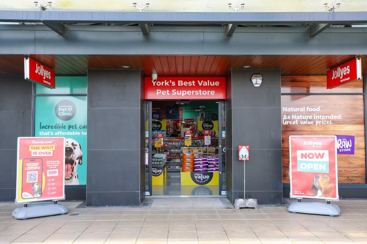 Entrance to Jollyes Pet Superstore in York, featuring bright signage, promotional banners, and pet supplies visible inside.