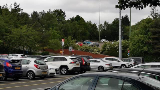Park and Ride facility with numerous parked cars, green trees, and a cloudy sky in Carbrook, Yorkshire.