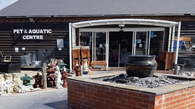 Entrance of Wentworth Pet & Aquatic Centre with a stone fountain and decorative items outside.