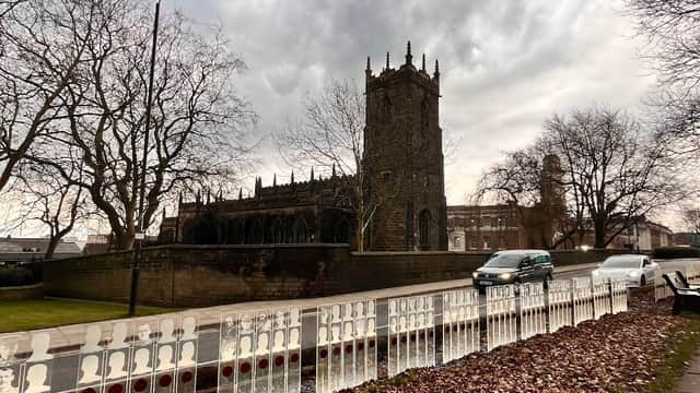 Churchfields Commuter Car Park with a church tower, bare trees, and a cloudy sky in Barnsley, Yorkshire.