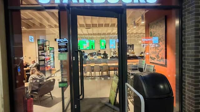 Starbucks entrance at Barnsley Retail Park, featuring outdoor seating and a visible trash bin nearby.