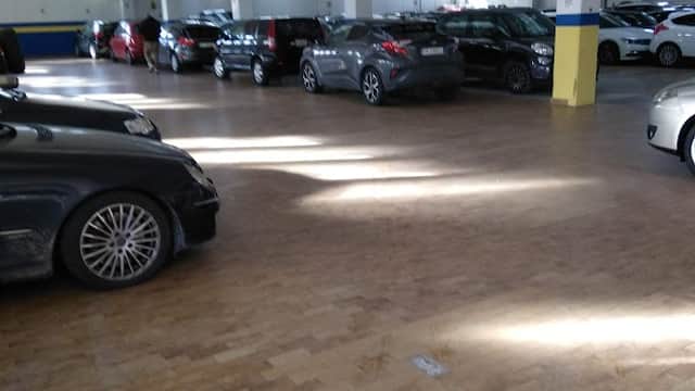 Pay & Display parking area in Beeston, Yorkshire, with multiple parked cars and bright overhead lighting.