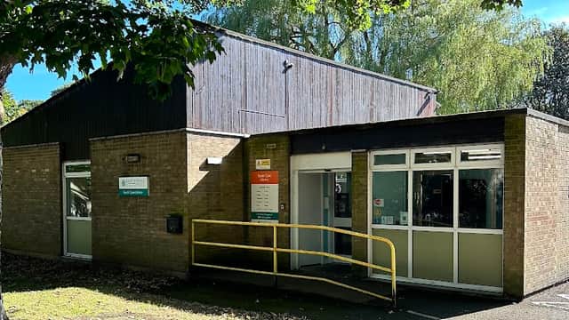 South Cave Library features a modern brick building with large windows and a yellow ramp for accessibility, surrounded by trees.