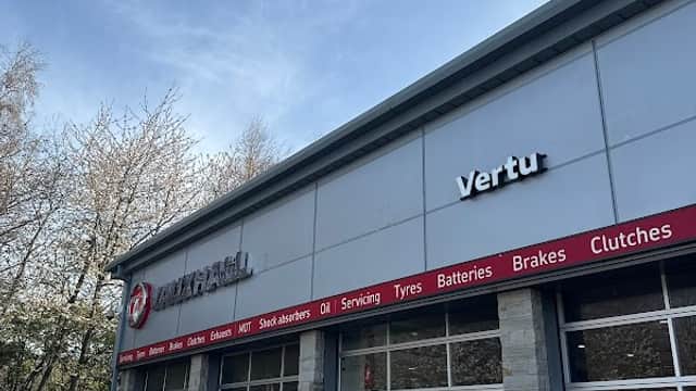 Vertu Vauxhall shop exterior in Cross Hills, Yorkshire, featuring service bays and signage under a clear blue sky.