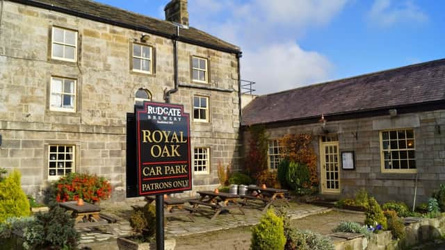 Royal Oak Inn with stone exterior, outdoor seating, and a sign indicating the car park for patrons only.