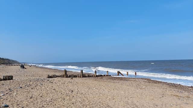 Morrow Ave Car Park near Hornsea beach, sandy shore, gentle waves, and a clear blue sky.