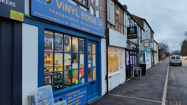 Vinyl Eddie store front with blue signage, displaying records and music-related items in a quaint York street.
