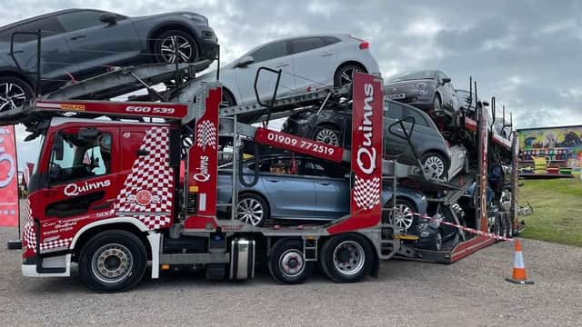 Quinns Car Transport truck loaded with multiple cars, parked in a Pay & Display area in Anston, Yorkshire.