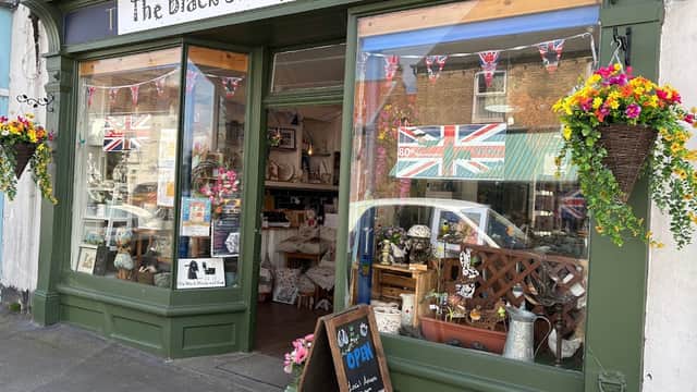 Quaint shopfront with floral displays, bunting, and a chalkboard sign reading "Open" in Patrington, Yorkshire.