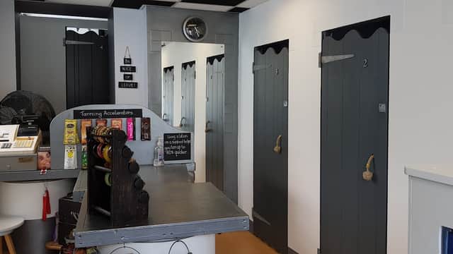 Interior of "Standing Room Only" with a reception desk, lockers, and numbered changing rooms in a modern design.