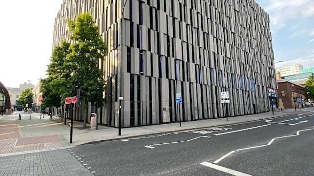 Modern multi-story car park with a textured facade, located at The Moor in Sheffield, Yorkshire, under a clear blue sky.