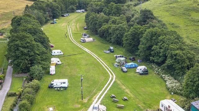 Aerial view of Low Farm Campsite in Ellerburn, featuring green fields, camping vehicles, and surrounding hills.