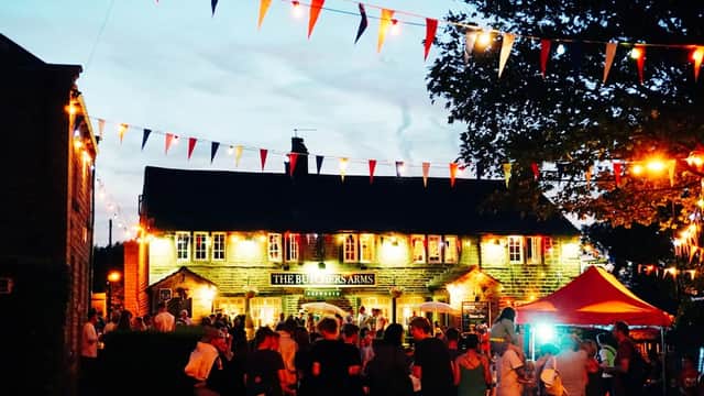 Hepworth Village Hall adorned with colorful bunting, bustling crowd, and warm lights during an evening event.