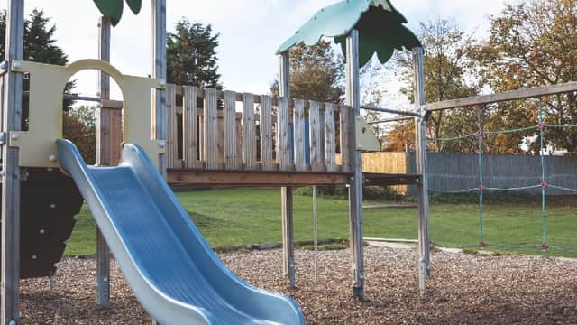 Playground at Haven Primrose Valley Holiday Park featuring a slide, climbing structure, and surrounding grass area.