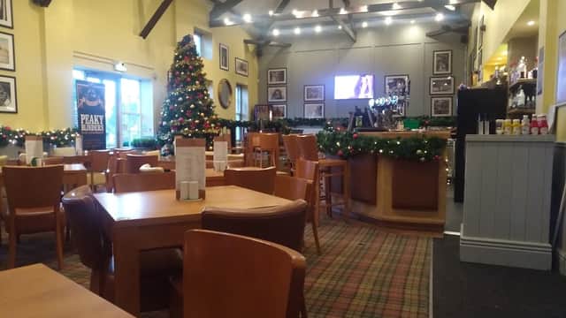 Cozy pub interior with wooden tables, festive decorations, a Christmas tree, and a bar area in Kirby Misperton.