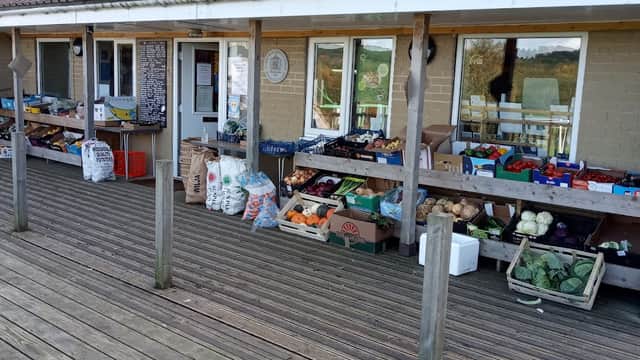 Darley Post Office features a wooden deck with fresh produce displayed in crates and bags outside the entrance.