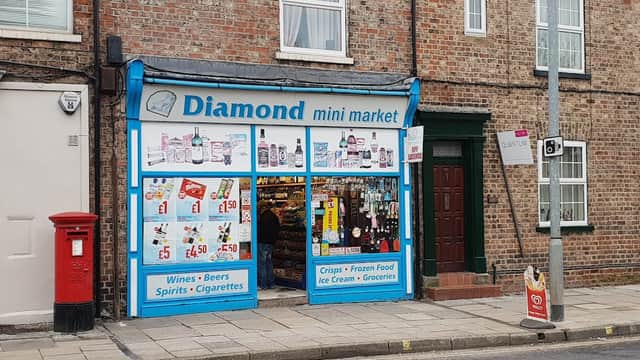 Brightly colored storefront of Diamond Mini Market with various products displayed, including drinks and groceries.
