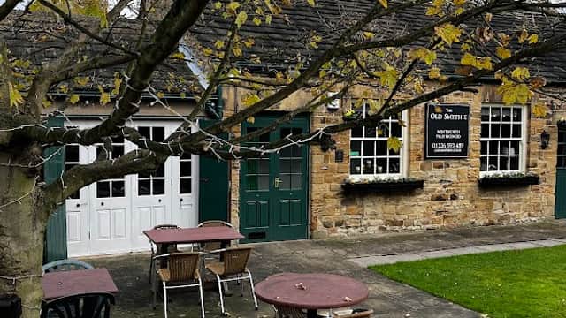 Quaint stone restaurant with green doors, outdoor seating, and a tree shedding leaves in Wentworth, Yorkshire.