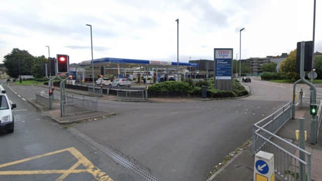 Tesco petrol station in Batley, Yorkshire, with cars and traffic lights visible on a cloudy day.