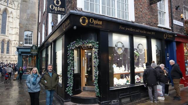Jewellery shop Ogden of Harrogate with festive decorations, people walking by, and historic buildings in York.
