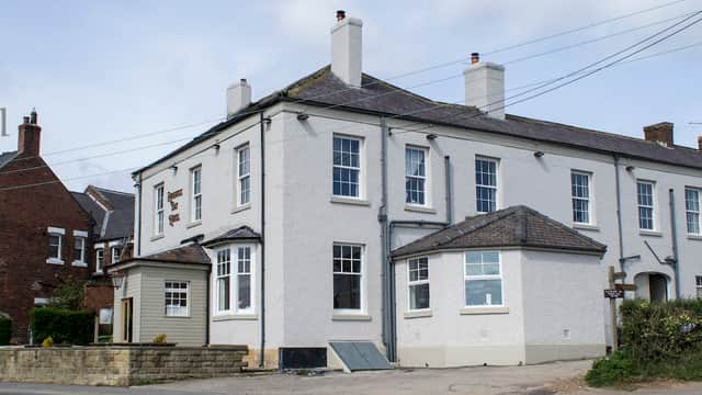 Runswick Bay Hotel's white exterior, large windows, and surrounding greenery in Hinderwell, Yorkshire.