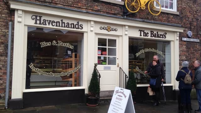 Havenhands The Bakers storefront with yellow bicycle decor, menu signage, and customers outside in Boroughbridge, Yorkshire.