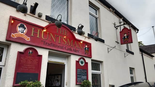 Traditional pub exterior with red signage, lanterns, and a welcoming entrance in Millhouse Green, Yorkshire.