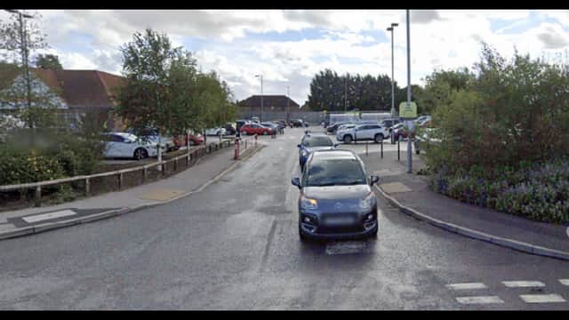 Pay & Display parking area in Pocklington, Yorkshire, with cars parked and greenery along the roadside.