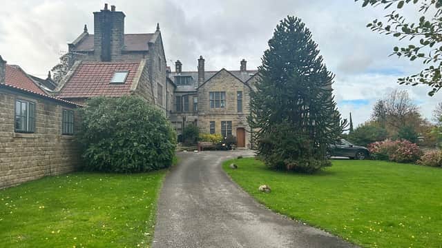Historic stone building with a landscaped garden and driveway, surrounded by trees and shrubs in Dunsley, North Yorkshire.