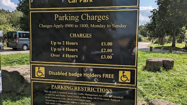 Welcome sign for Anglers Country Park with parking charges and restrictions listed, surrounded by greenery.