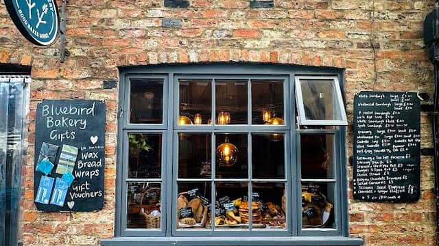 Charming bakery with a rustic brick facade, window display of baked goods, and chalkboard menu.