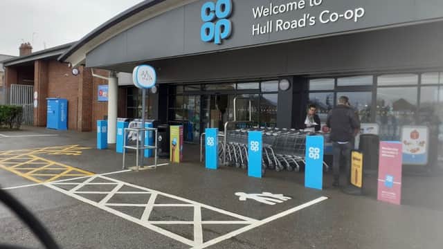 Co-op Food storefront with shopping carts outside, signage welcoming visitors, and accessible parking spaces.