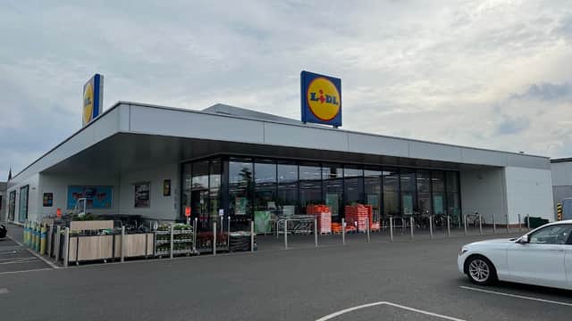 Lidl grocery store in York, featuring a modern facade, shopping carts, and a parking area with a car.