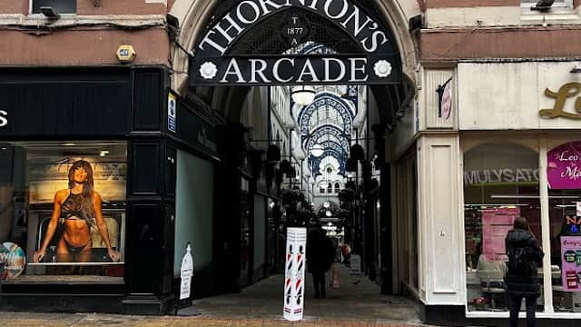 Entrance to Thornton's Arcade with shops on either side and a patterned brick pathway.