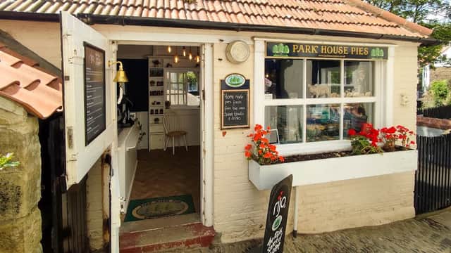 Quaint shopfront of Park House Pies with a welcoming entrance, flower boxes, and a sign displaying the shop name.