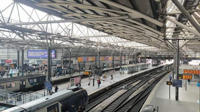 Pay & Display car park at Leeds Station, with trains and passengers under a large, open roof structure.