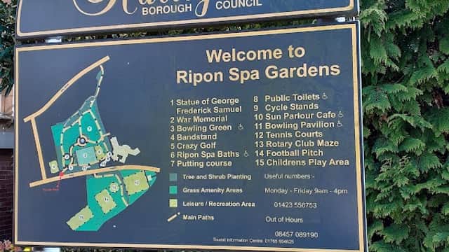 Sign welcoming visitors to Ripon Spa Gardens, featuring a map and listing amenities like toilets, café, and playground.