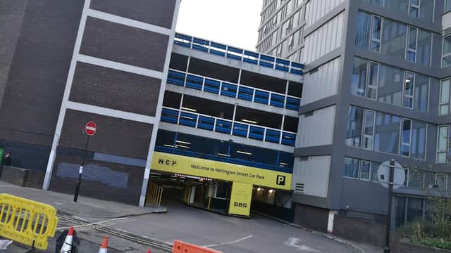 NCP Wellington Street car park entrance with barriers, signage, and adjacent modern buildings in Sheffield.