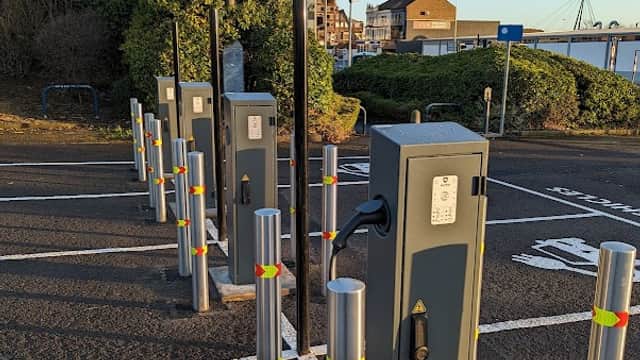 Pay & Display car park with charging stations, metal posts, and green shrubbery in Thornaby, Yorkshire.
