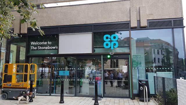 Co-op Food storefront at The Stonebow, featuring glass entrance, signage, and a nearby construction lift.