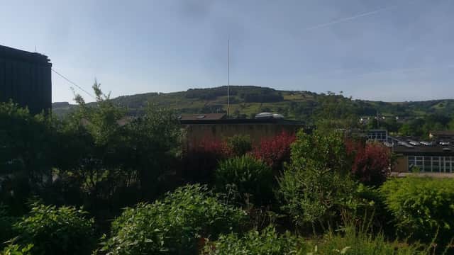 South Craven School surrounded by greenery, with rolling hills in the background under a clear blue sky.
