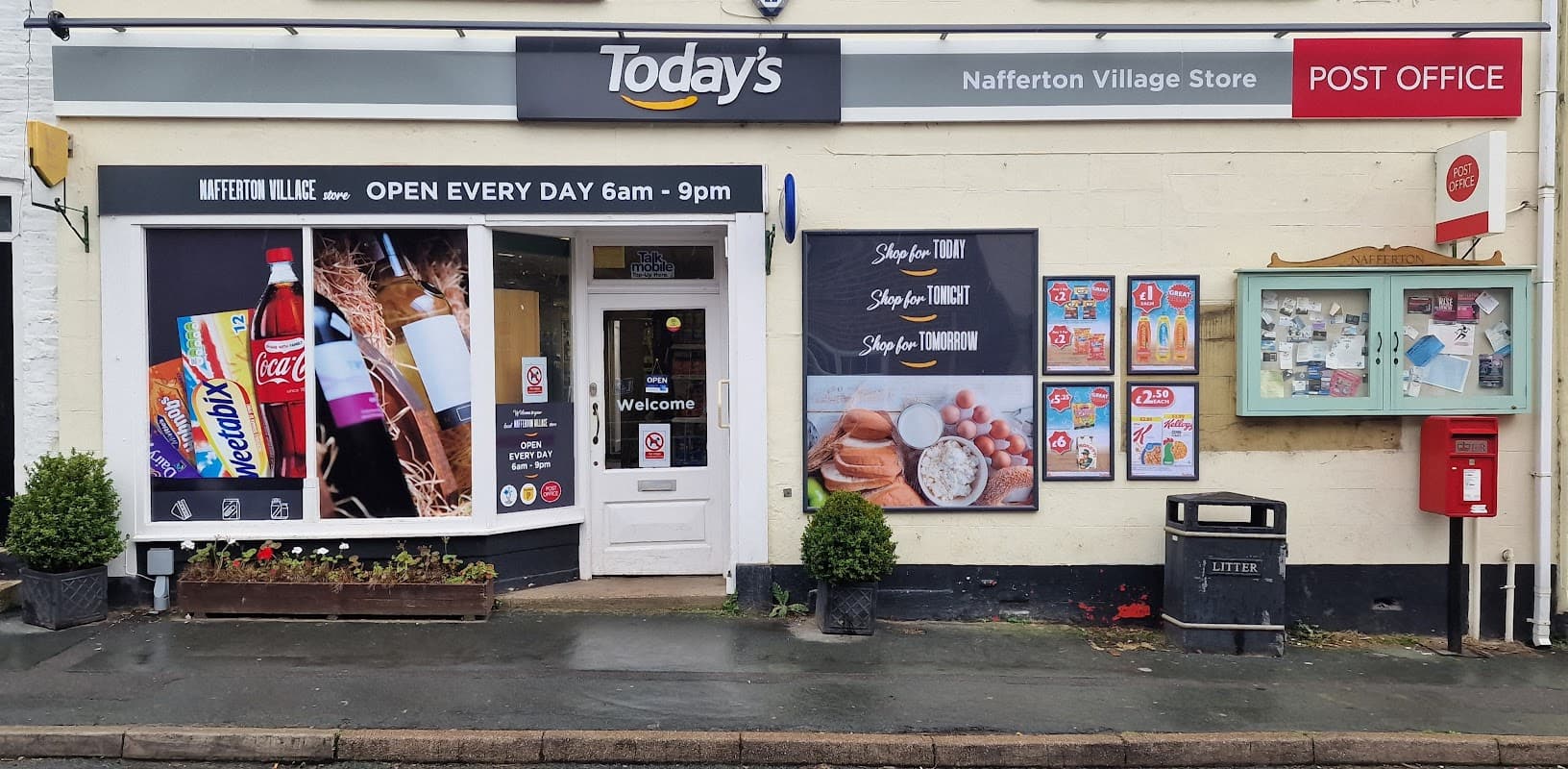 Nafferton Post Office storefront with signage, displays of drinks, and a bulletin board on a rainy day.