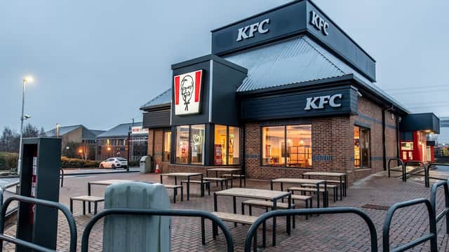 KFC restaurant with outdoor seating, illuminated signage, and a modern design in Birstall, Yorkshire.