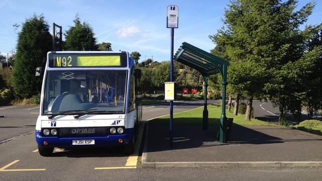 Bus stop with an M92 bus parked, surrounded by trees and a car park at Grenoside Crematorium in Yorkshire.