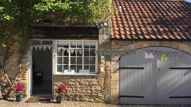 Charming stone building with a welcoming entrance, flower pots, and a rustic wooden door in Ebberston, Yorkshire.